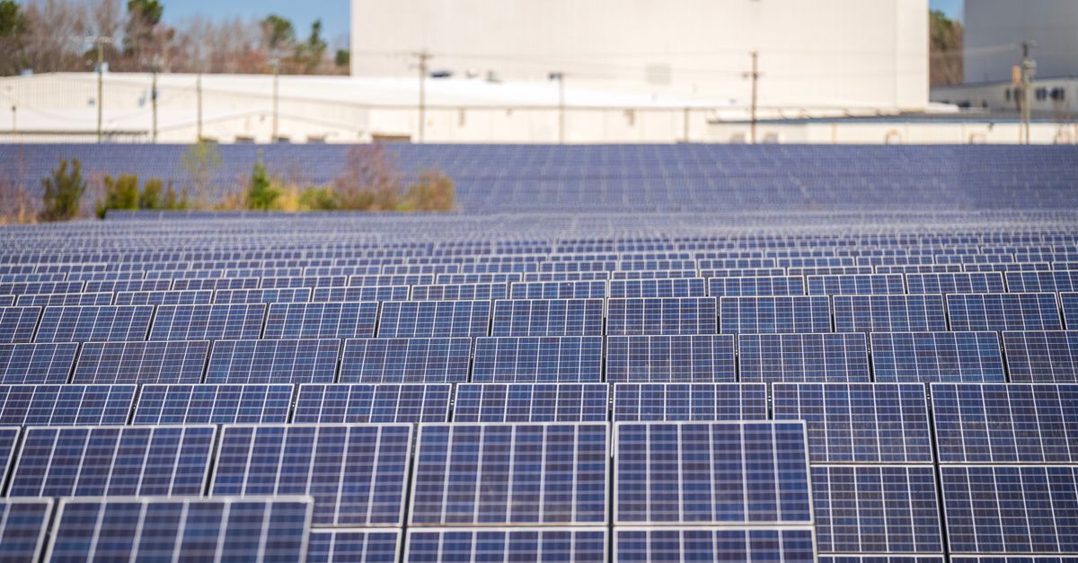 A large solar farm with photovoltaic panels generating renewable energy outdoors.